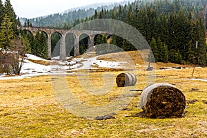 Slovakia train viaduct historical bridge in the forest and mountains. Historic railroad and transportation. Meadow with snow in fo