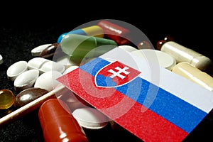 Slovakian flag with lot of medical pills isolated on black background