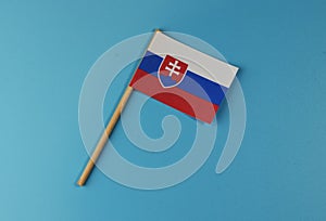 Slovenská vlajka ležící na modrém pozadí