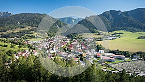 Slovenská obec Terchová s cintorínom v údolí medzi Fatrami. Kopce a skaly, modrá obloha.