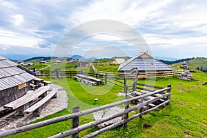 Slovenia velika planina big plateau, agriculture pasture land near city Kamnik in Slovenian Alps. Wooden houses on green land photo