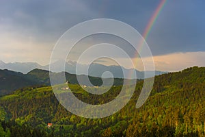 Slovenian breathtaking landscape with Julian Alps and charming little church of Sveti Tomaz Saint Thomas on a hill. Beautiful