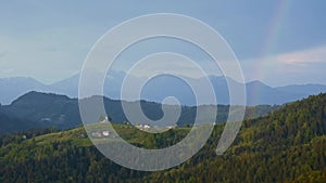 Slovenian breathtaking landscape with Julian Alps and charming little church of Sveti Tomaz Saint Thomas on a hill. Beautiful