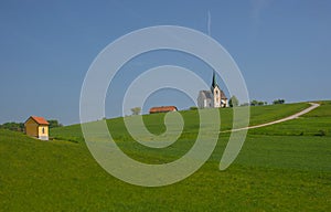 Slovenian countryside in spring with charming little church on a hill, in Slovenia