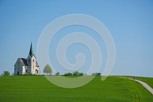 Slovenian countryside in spring with charming little church on a hill, in Slovenia