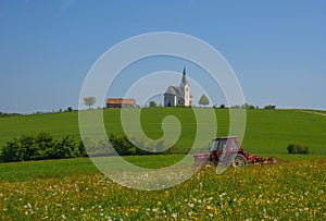 Slovenian countryside in spring with charming little church on a hill, in Slovenia