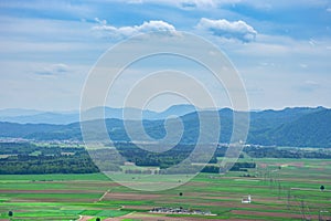 Slovenian countryside in spring with charming little church in the middle of a field and Julian Alps in the background