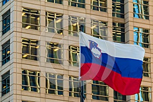 Slovenian flag on the background of office building, Atlanta, USA