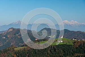 Slovenian rural mountain village with Kamnik Alps in the background, landscape view.
