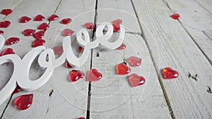 Slow close-up slide shot of Love sign with red hearts around. Valentines day.