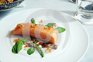 Slow Cooked Salmon fillet steak with salad and roe salmon on white plate