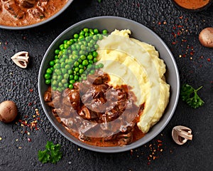 Slow Cooked Steak Diane Casserole with mushroom. mashed potatoes and green peas