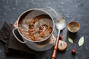 Slow cooker beef ragu. Crock pot braised beef on dark background. photo