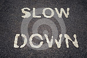 SLOW DOWN print on asphalt