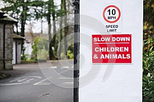 Slow down road safety caution children and animals at zoo entrance