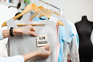 Slow fashion. Clothes on hangers in a shop showcase. Recycled organic apparel