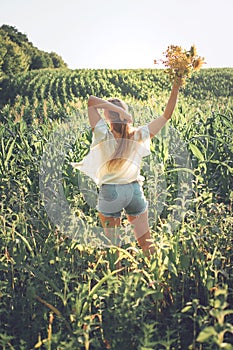 Slow Living concept New Lifestyle Trend. Relaxing young woman with lowers in nature, in corn, sunflower field