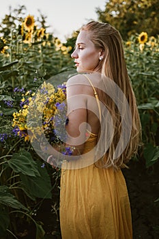 Slow Living concept New Lifestyle Trend. Relaxing young woman with lowers in nature, in corn, sunflower field