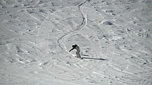 Slow motion active sport male snowboarder ride on track surrounded by snow aerial shot