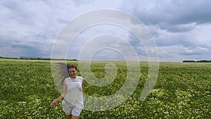 Slow motion aerial of woman running in flower field summer happiness joy of life