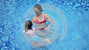 slow motion asian Chinese mother and daughter playing at the pool