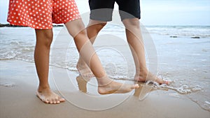 Slow motion Asian little girl walking with mother on the beach with nature sea wave coast for summer vacation concept