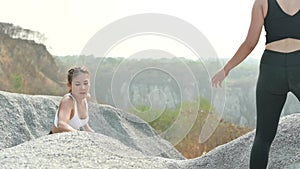Slow motion athlete woman helping friend for running at the rock. Asian female runner endurance