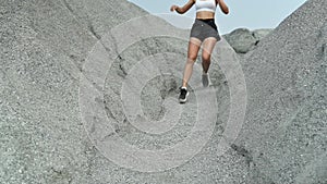 Slow motion athlete woman running at the rock. Asian female runner endurance training in summer.
