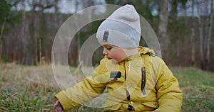 Slow motion. A boy in a yellow jacket stands and looks at the beauty of the forest and the planet earth. Watch and dream