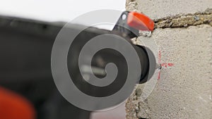 SLOW MOTION,: Builder working uses an electric drill to mount a wall panel. Man drills hole using perforator. Male hands