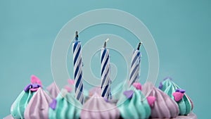 slow motion of burning candle on a birthday cake on light purple background