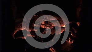 Slow motion. Burning coal in the stove. Live coal, embers, glowing coals, abstract background.