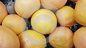 Slow motion camera over close-up video of a pile of ripe grapefruits in a supermarket, 4k video