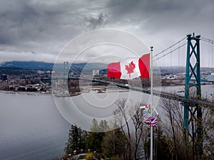 Canadian flag waving at Prospect Point in Stanley Park with the Lions Gate Bridge in the background in Vancouver, BC.