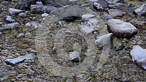 Slow-motion capture of flowing water in a stream between the rocks. Flowing water in a small mountain brook