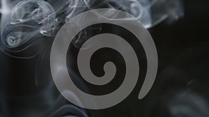 SLOW MOTION: Cigarette smoke on a black background