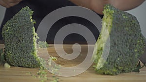 Slow motion - Close up of chief woman making salad healthy food and chopping broccoli on cutting board in the kitchen