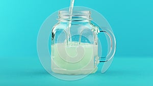 Slow motion close-up shot of fruit fizzy lemonade soda cold beverage drink pooring into glass jar mug blue background in