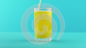 Slow motion close-up shot of fruit orange multifruit juice cold beverage drink pooring into glass mug with handle blue