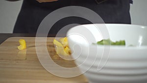 Slow motion - Close up of woman making healthy food and chopping bell pepper on cutting board in the kitchen