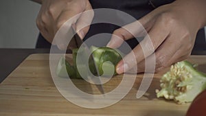 Slow motion - Close up of woman making healthy food and chopping bell pepper on cutting board in the kitchen