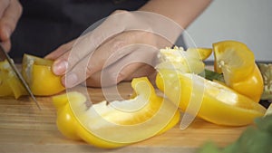 Slow motion - Close up of woman making healthy food and chopping bellpepper on cutting board in the kitchen.