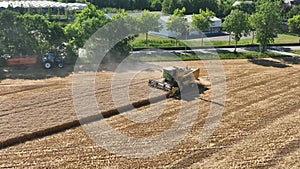 Slow motion combine harvester agriculture farm land grain harvest machinery in golden colored field farming industry in