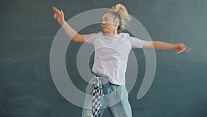 Slow motion of cute blonde dancing on grey background twerking indoors