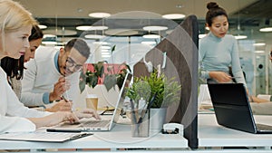 Slow motion of diverse group of people coworkers busy in open space office working talking