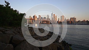 SLOW MOTION: downtown Manhattan View close to water with Brooklyn Bridge in Beautiful Sunrise Sunlight in Summer Water