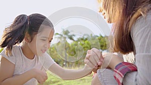 Slow motion of Elder sister and sister play together in park. Younger sister annoyed elder sister because she teased. young mother