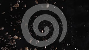 Slow motion of exploding coffee beans towards the camera. coffee seeds bounce after fall