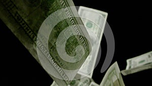 Slow motion of falling 100 dollars on black background. Dollar bills falling down.