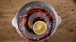 Slow motion of falling orange slice in mulled wine kettle